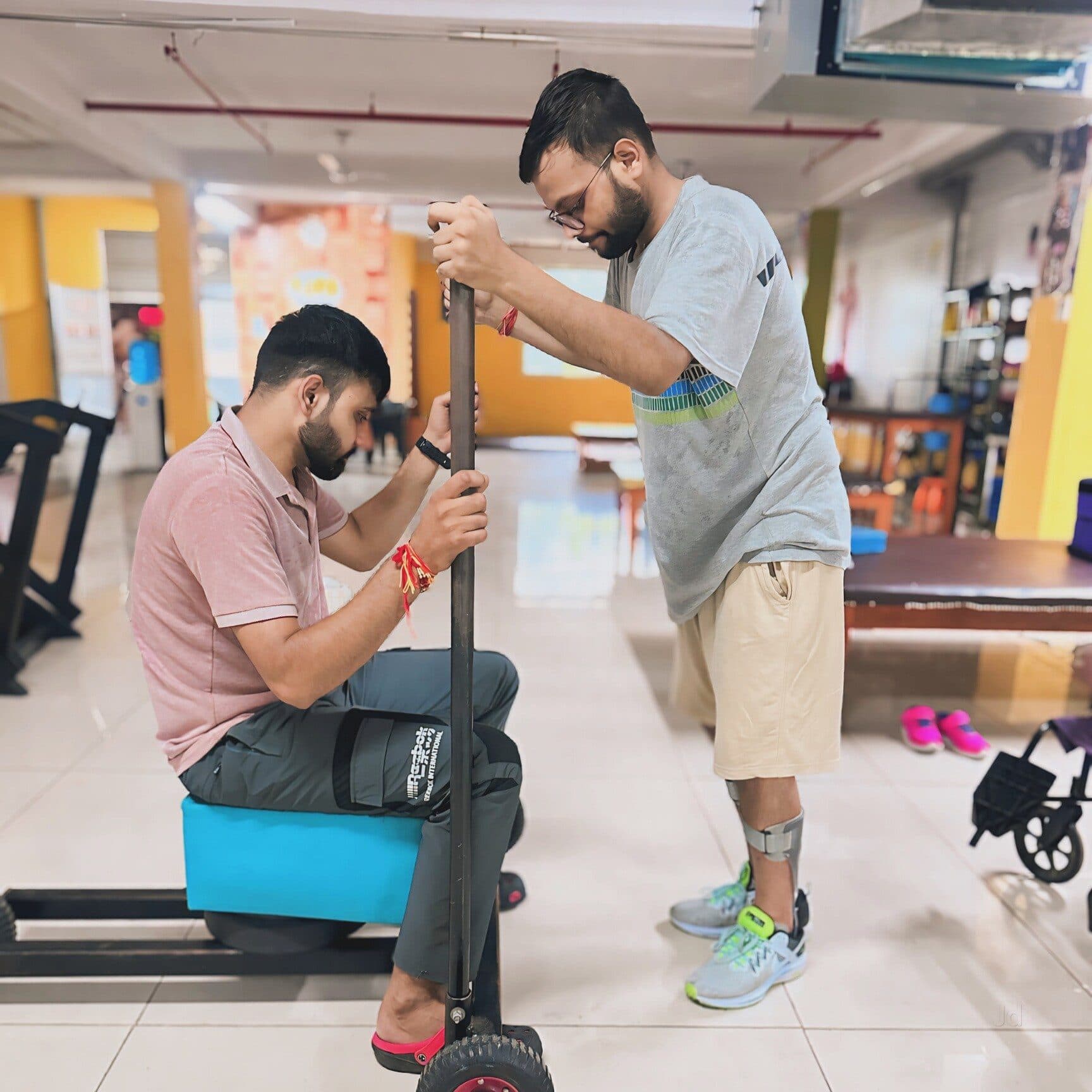 A Quick Walk physiotherapist adjusting a walking aid for a seated patient in the rehabilitation gym
